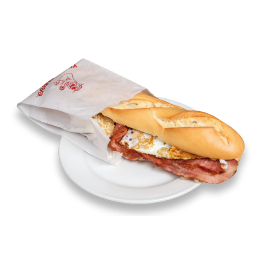 Bocadillo tipo baguette con huevo a la plancha y bacon, parcialmente envuelto en papel con logotipo, servido sobre plato blanco; Yogui Burger en Torrejón de Ardoz.